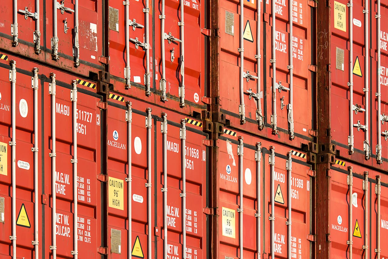 services-03 Close-up of stacked red shipping containers used for logistics and global trade.