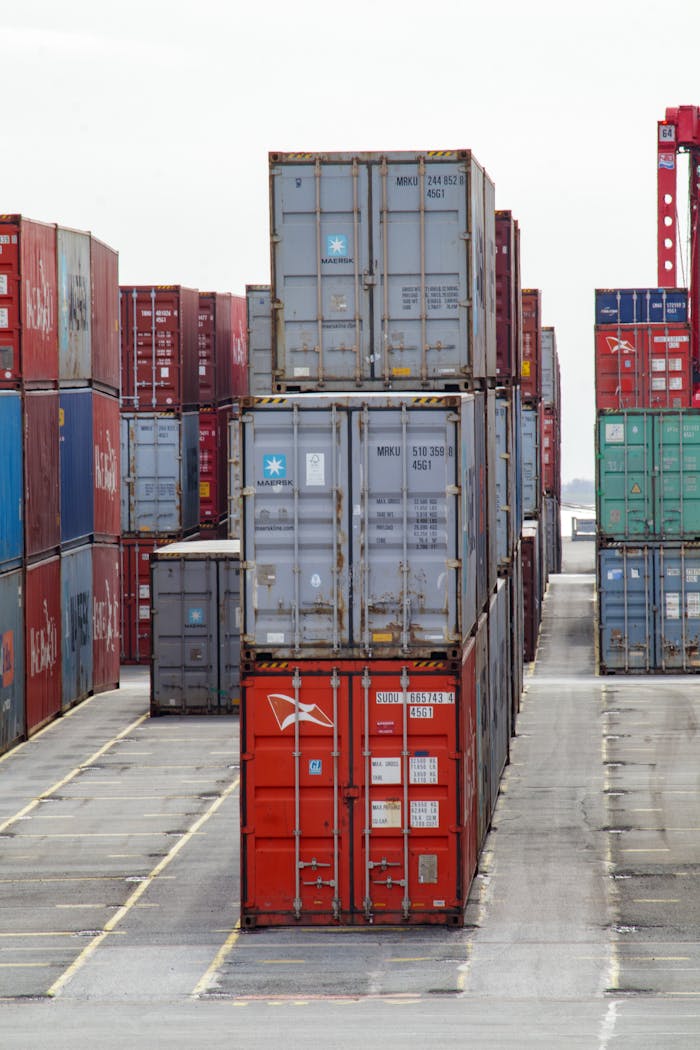journey Vertical shot of colorful shipping containers stacked at an industrial port, showcasing logistics.
