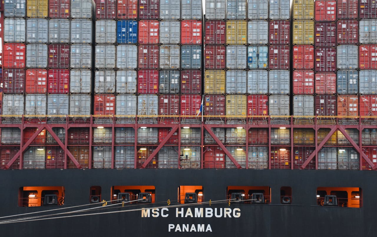 services-01 Stacked shipping containers aboard MSC Hamburg at the bustling port of Hamburg.